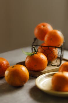 A rustic arrangement of fresh Vietnamese oranges in soft light, showcasing their vibrant color.