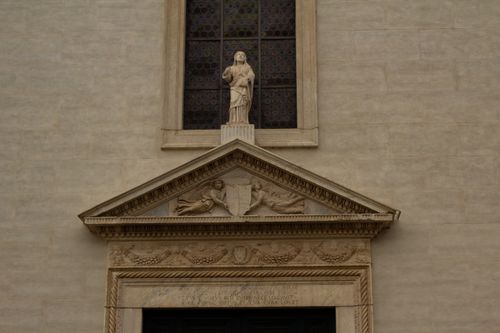 Free Detailed view of a historic stone facade featuring a religious statue. Stock Photo