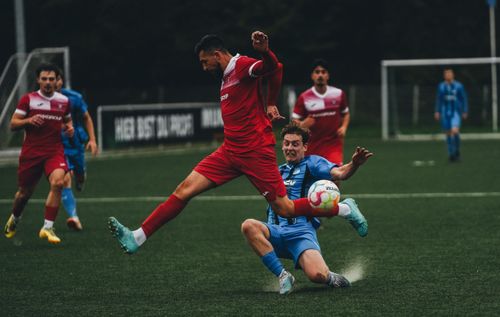 Free Intense soccer match with players in mid-jump and tackle on a green field. Captivating sports action. Stock Photo