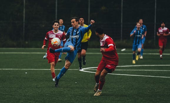 Players in action during a competitive football match on an outdoor field.