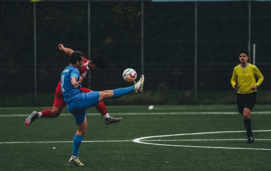 Action-packed soccer game showing two athletes competing for the ball on the field.