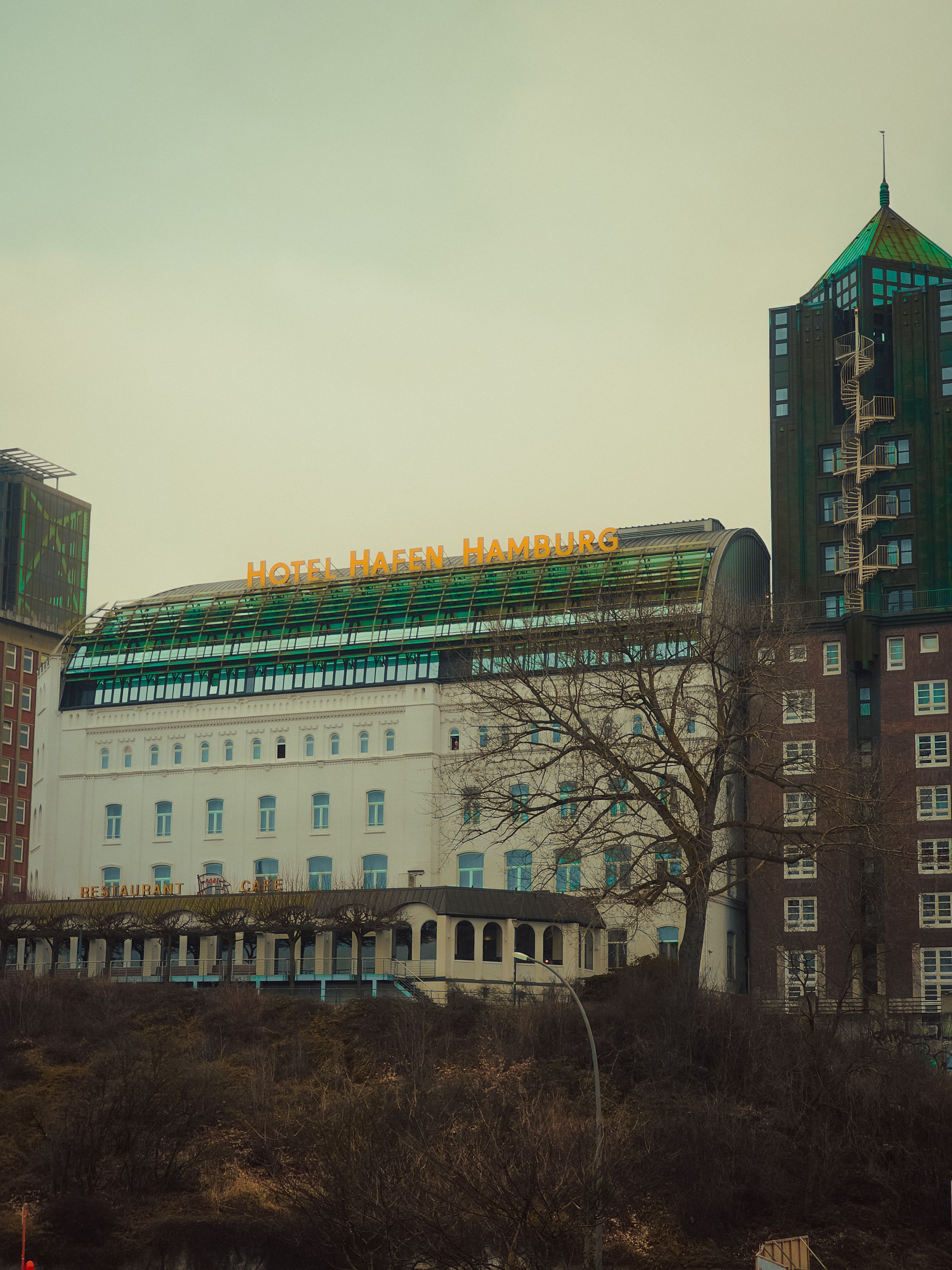 View of Hotel Hafen Hamburg, a prominent landmark against an overcast sky highlighting its architecture.