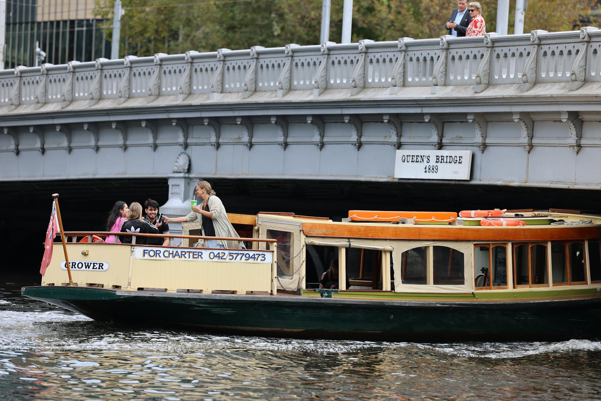 Tourists enjoying a chartered boat ride under Queen's Bridge in Melbourne.