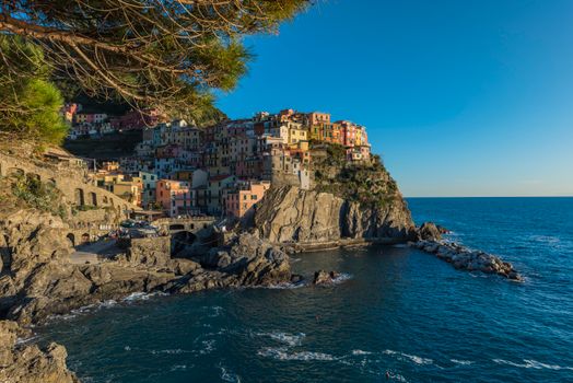 Stunning view of colorful Manarola perched on the rugged cliffs of Cinque Terre at sunset.