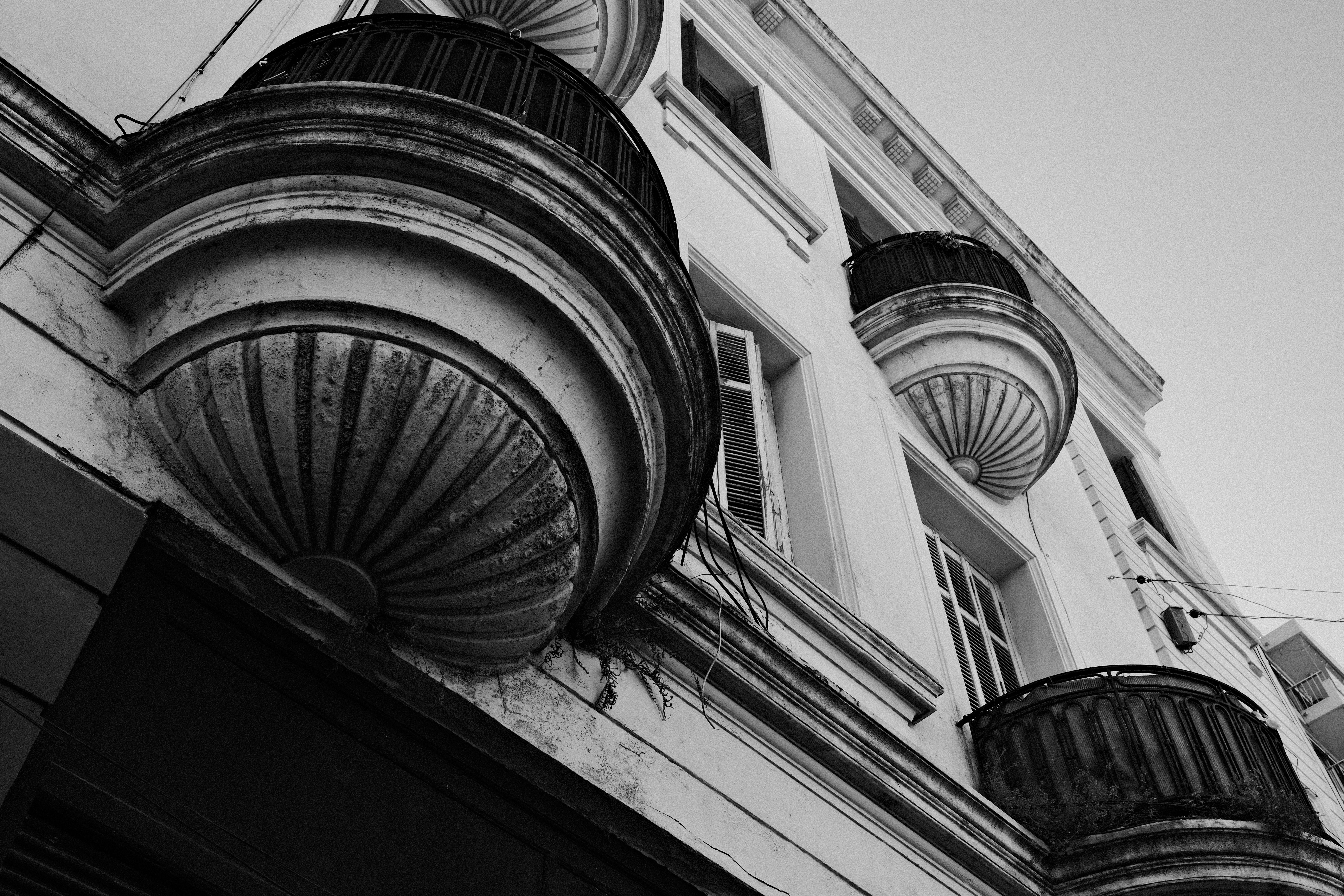 grátis Imagem em preto e branco de uma fachada de edifício clássico com varandas ornamentadas. Foto profissional