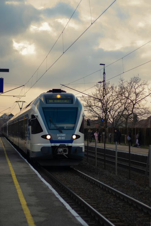 Free Electric train arrives at station under dramatic sky, symbolizing travel and transportation. Stock Photo