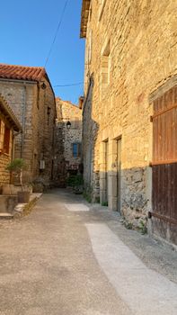 Sunlit alleyway in Saint-Rome-de-Tarn, showcasing rustic stone buildings and European architecture. — photo by famas