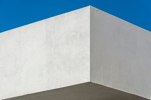 Free A minimalist architectural corner against a clear blue sky, showcasing modern design. Stock Photo