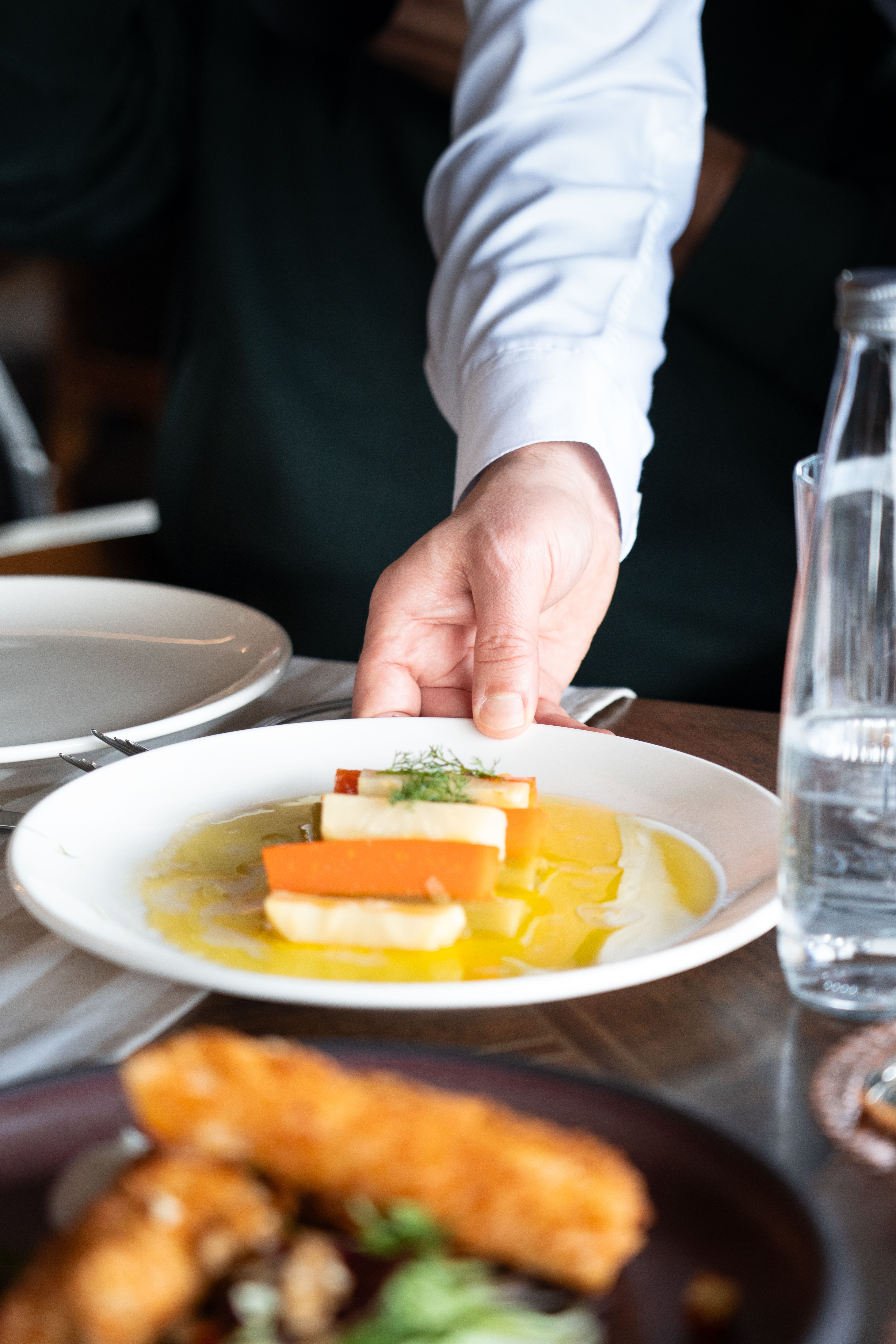 Chef serving an elegant tasting menu dish