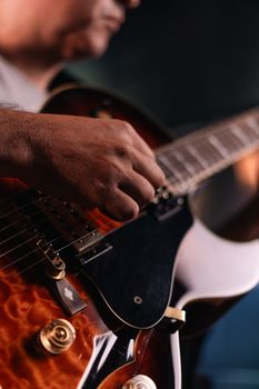 A musician strumming an electric guitar during a live performance.. musician, strumming, electric