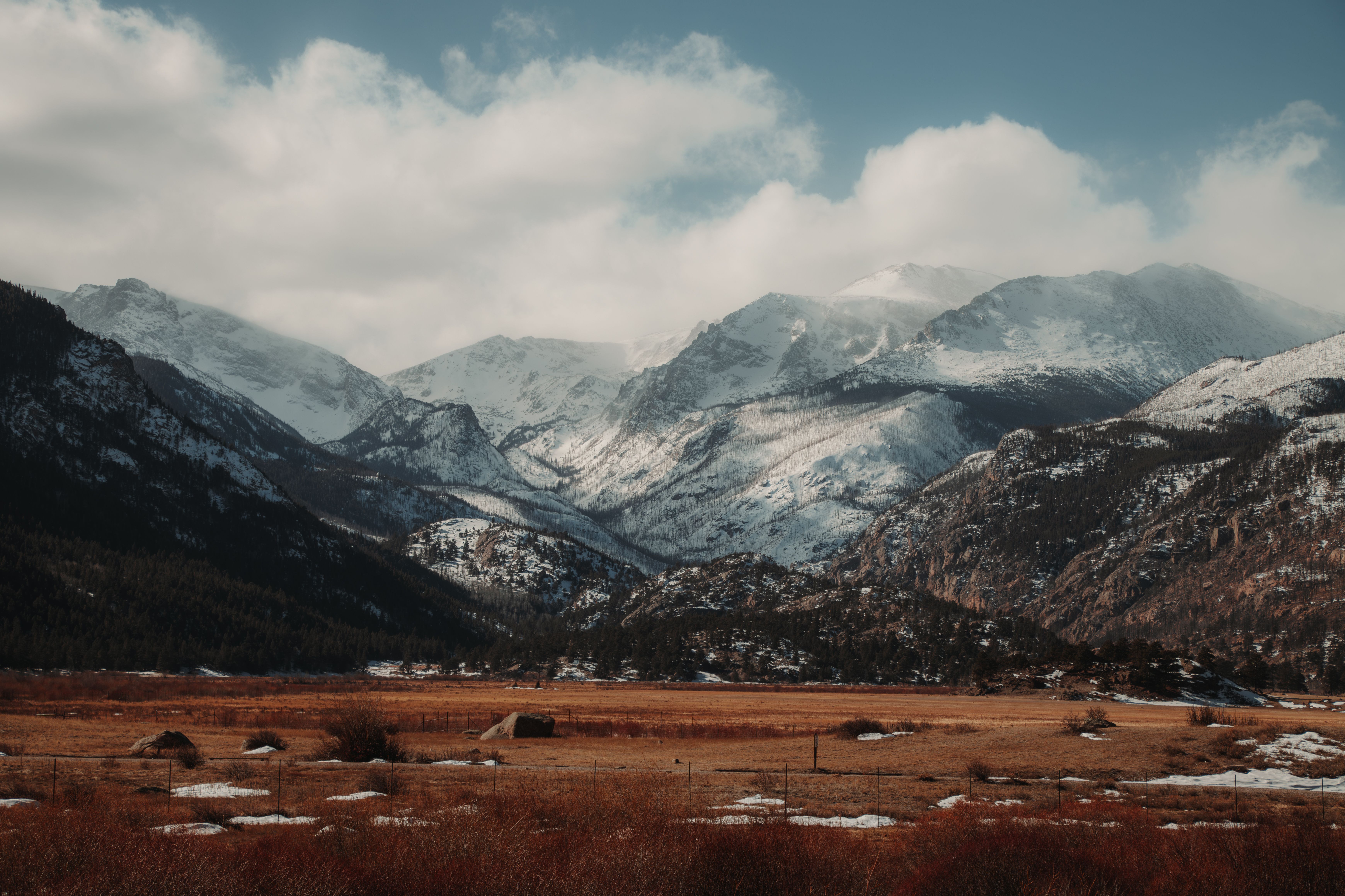Breathtaking view of snow-capped mountains in the Colorado Rockies under a bright winter sky.