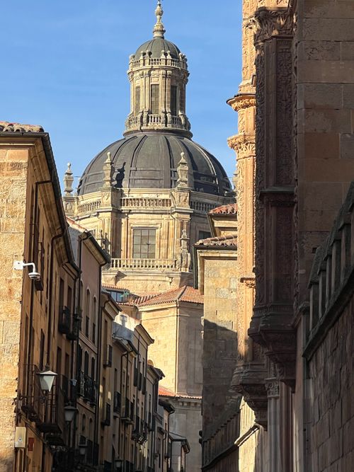 Free View of a historic dome and narrow street in Salamanca's old town, showcasing classic architecture. Stock Photo