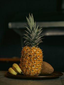 A captivating still life of tropical fruits including a pineapple, bananas, and a coconut.