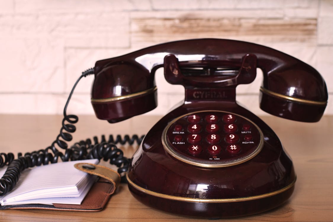 Free Maroon Push Button Telephone on Table Stock Photo