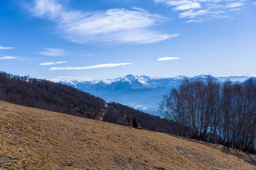 Breathtaking view of the Swiss Alps in springtime with clear blue skies and rugged terrain.