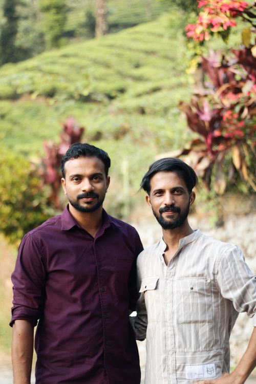 Free Two friends standing together amidst greenery in a tea plantation, enjoying nature. Stock Photo