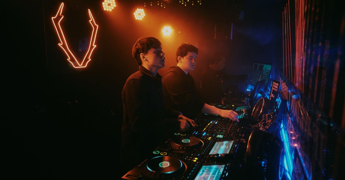 Corporate Raves Go Mainstream as K-Pop Crossover Reshapes Electronic Music Energetic nightclub scene with DJs performing amidst vibrant neon lights in Leon, Mexico.