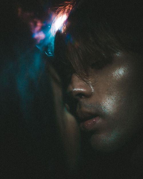 Free Artistic moody portrait of a young man with soft, iridescent lighting creating a dreamy atmosphere. Stock Photo