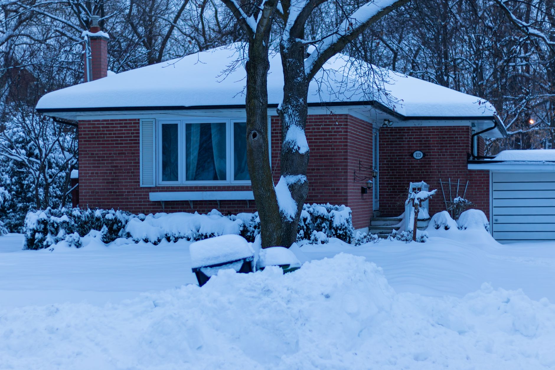 A serene winter morning scene of a snow-covered house in Toronto, Canada.
