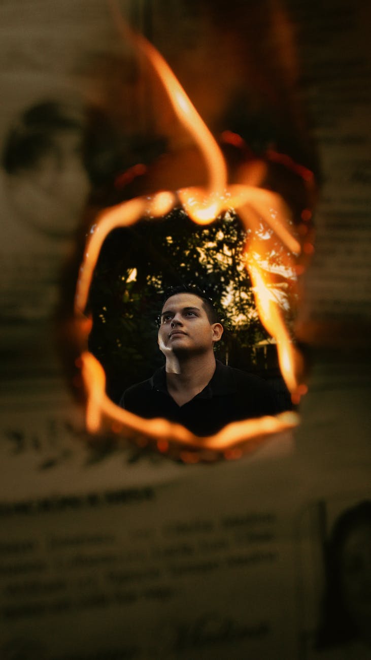 A dramatic portrait with a fiery burnt edge creating a striking frame effect.
