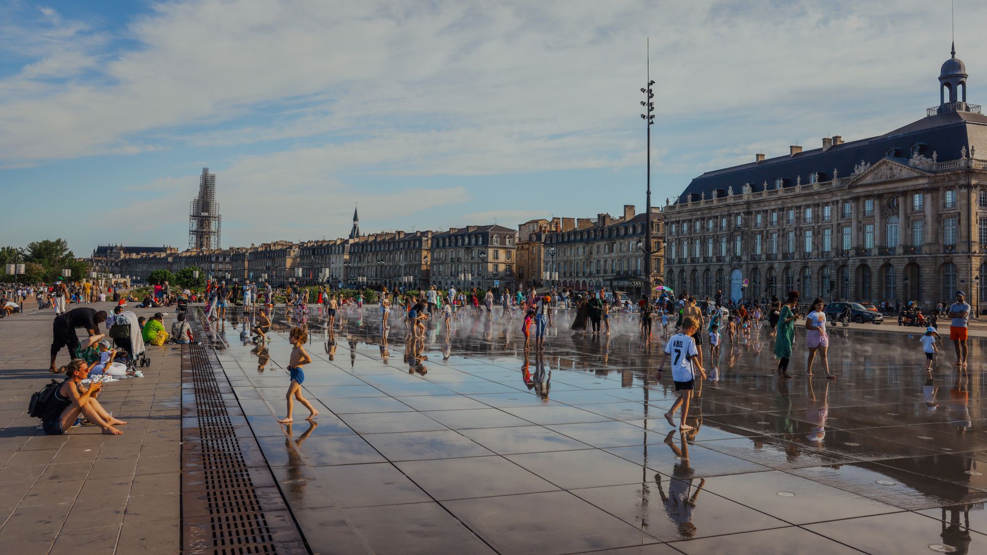 Lively scene at Bordeaux Place de la Bourse with families enjoying the reflecting pool.