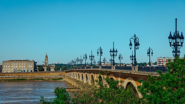 Elegant view of Pont de Pierre bridge in Bordeaux, France on a sunny day.