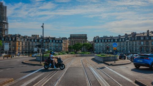 Free Busy street scene in Bordeaux, France featuring a motorbike and historic architecture on a sunny day. Stock Photo