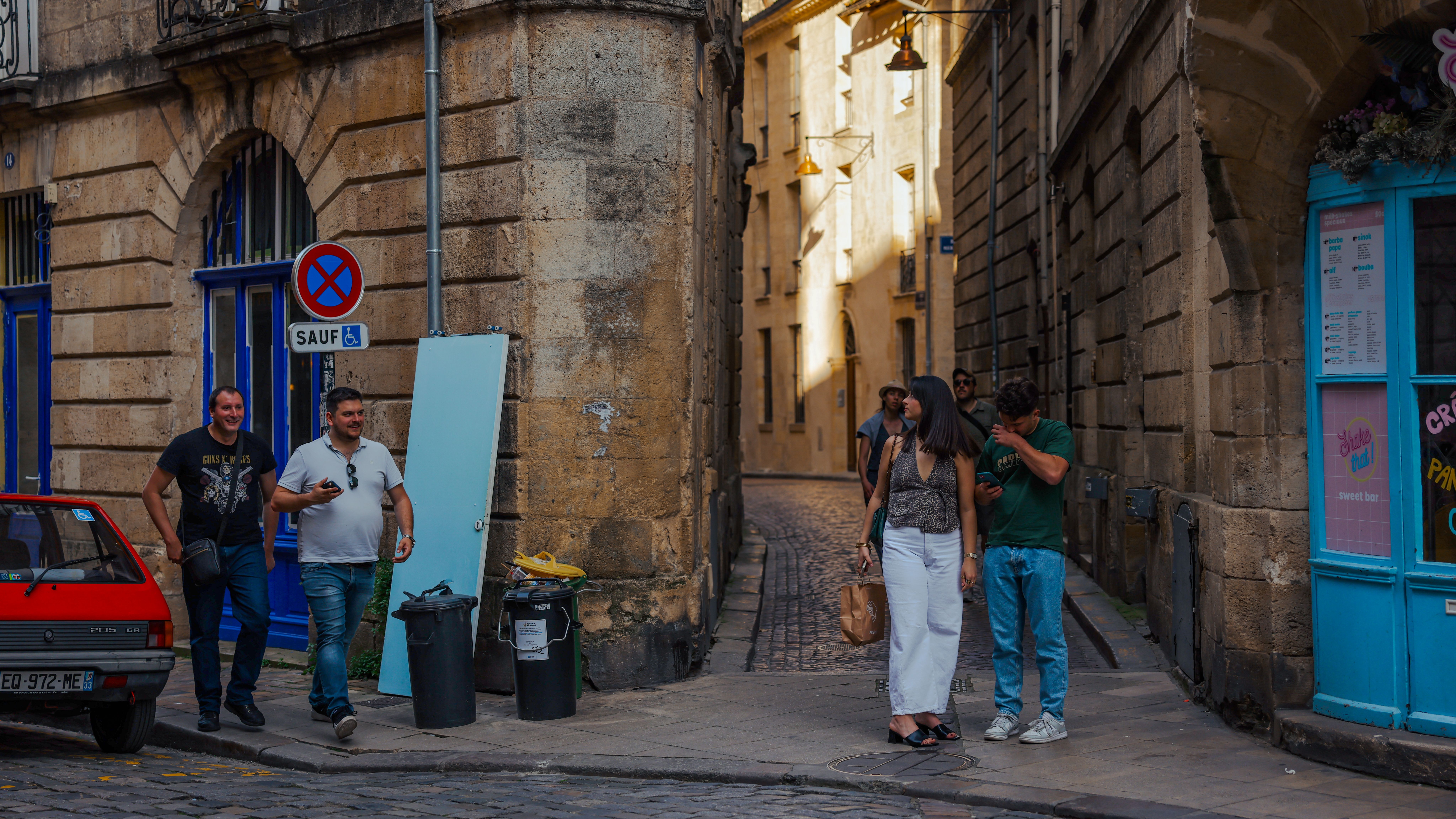 Casual street scene in Bordeaux, France with locals and historic architecture.