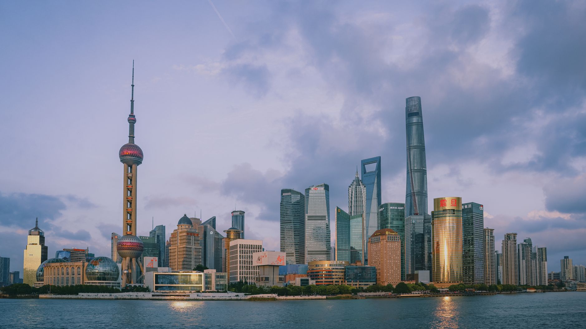 Panoramic view of Shanghai's modern skyline with famous skyscrapers at dusk.