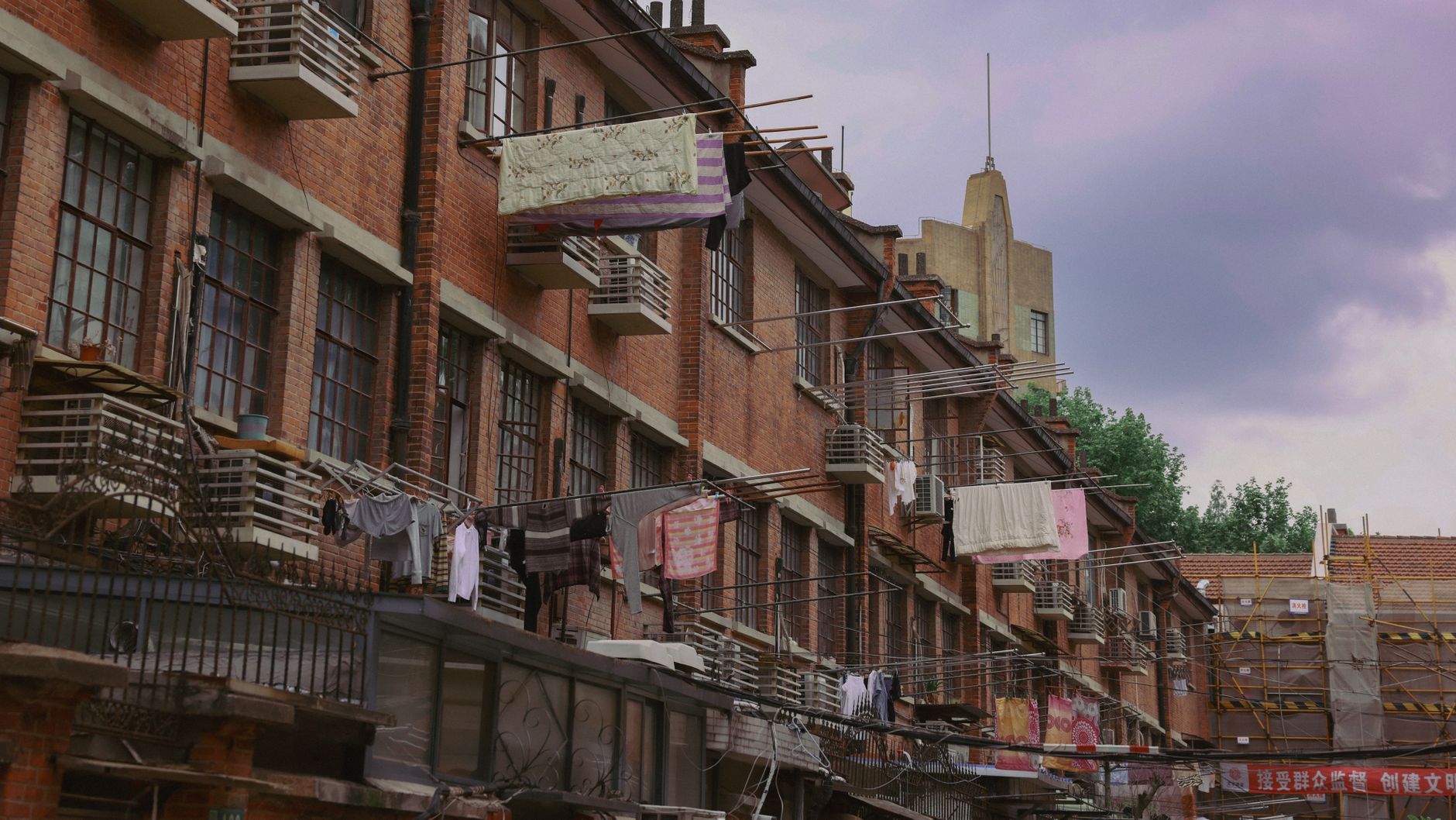 Historic brick lane houses in Shanghai with laundry drying, showcasing local lifestyle and architecture.