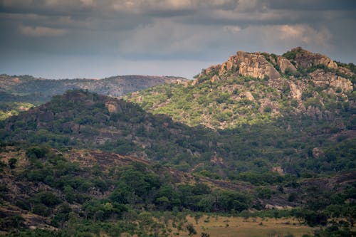 Free Green and Rocky Mountains Under Cloudy Sky Stock Photo