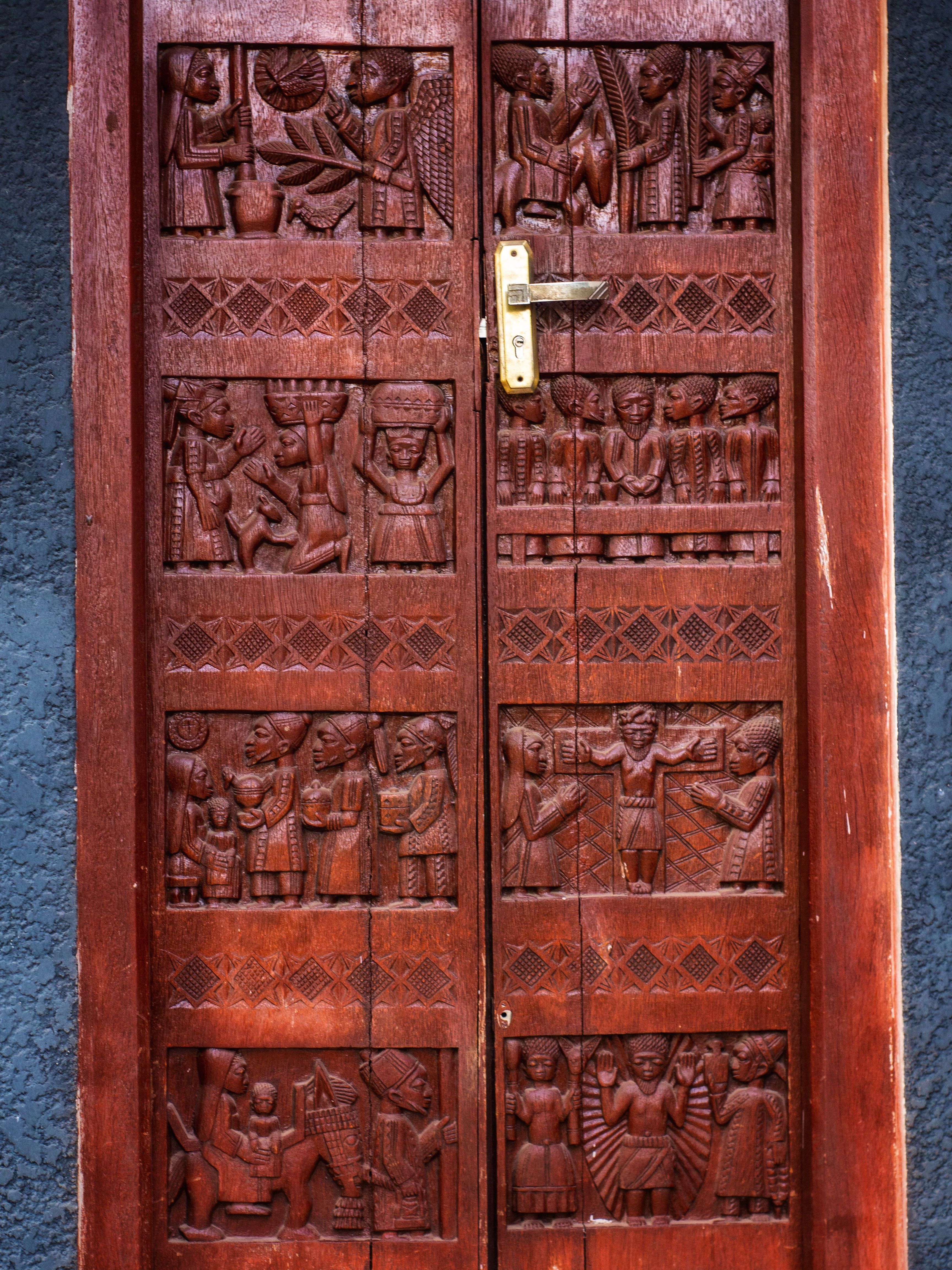 Intricately Carved Wooden Door with Cultural Scenes · Free Stock Photo