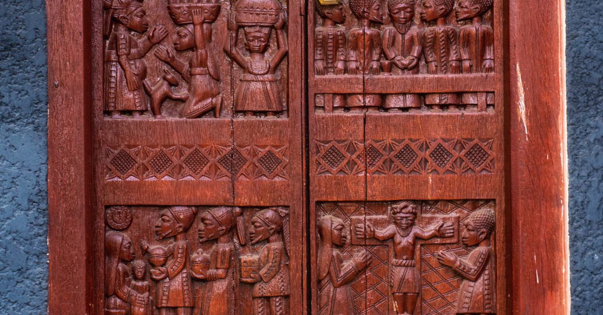 Intricately Carved Wooden Door with Cultural Scenes · Free Stock Photo