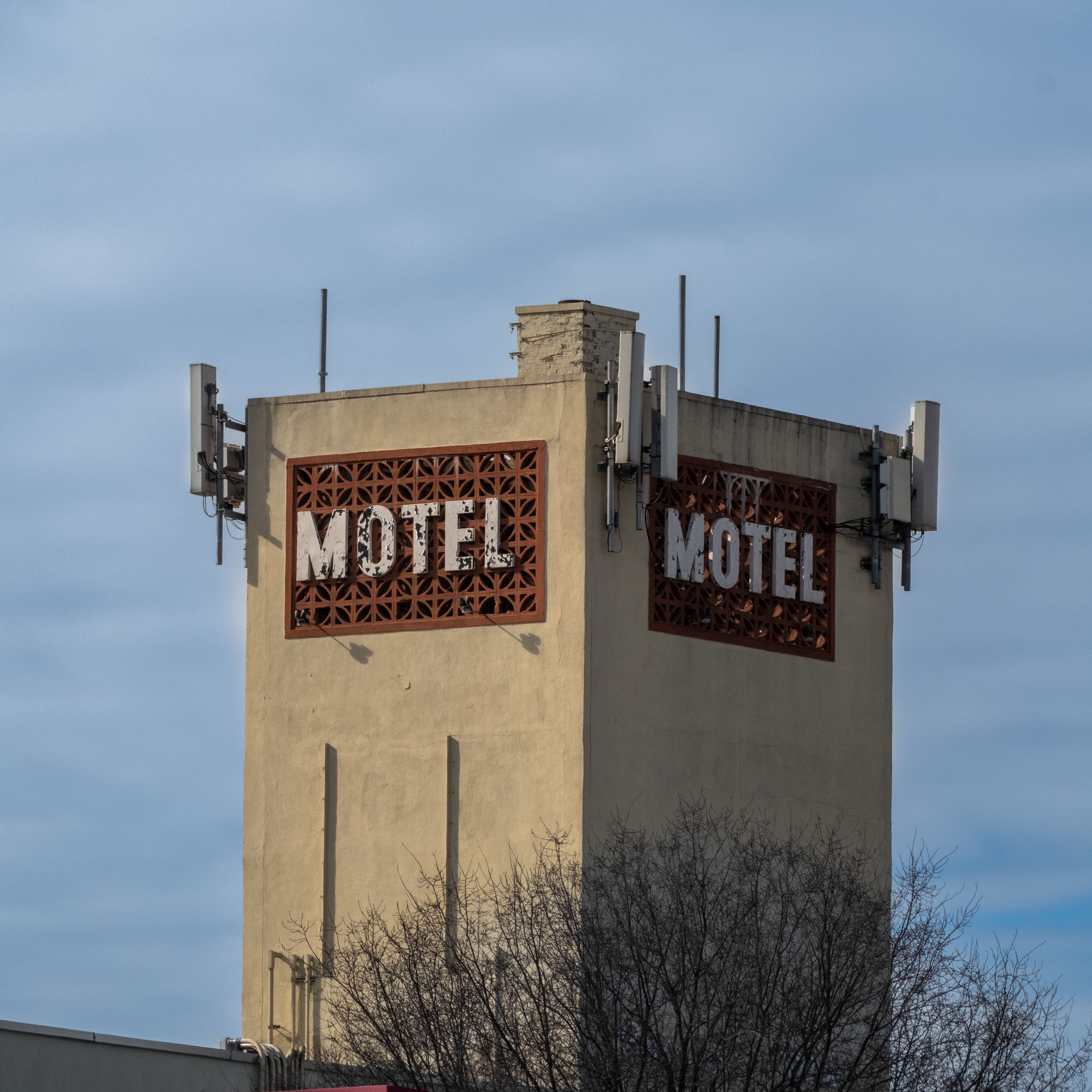 Retro Motel Sign with Urban Architecture · Free Stock Photo