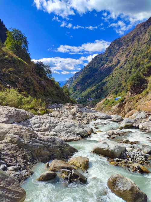 Free A picturesque mountain river flows through rugged terrain under a blue sky in Vera, India. Stock Photo
