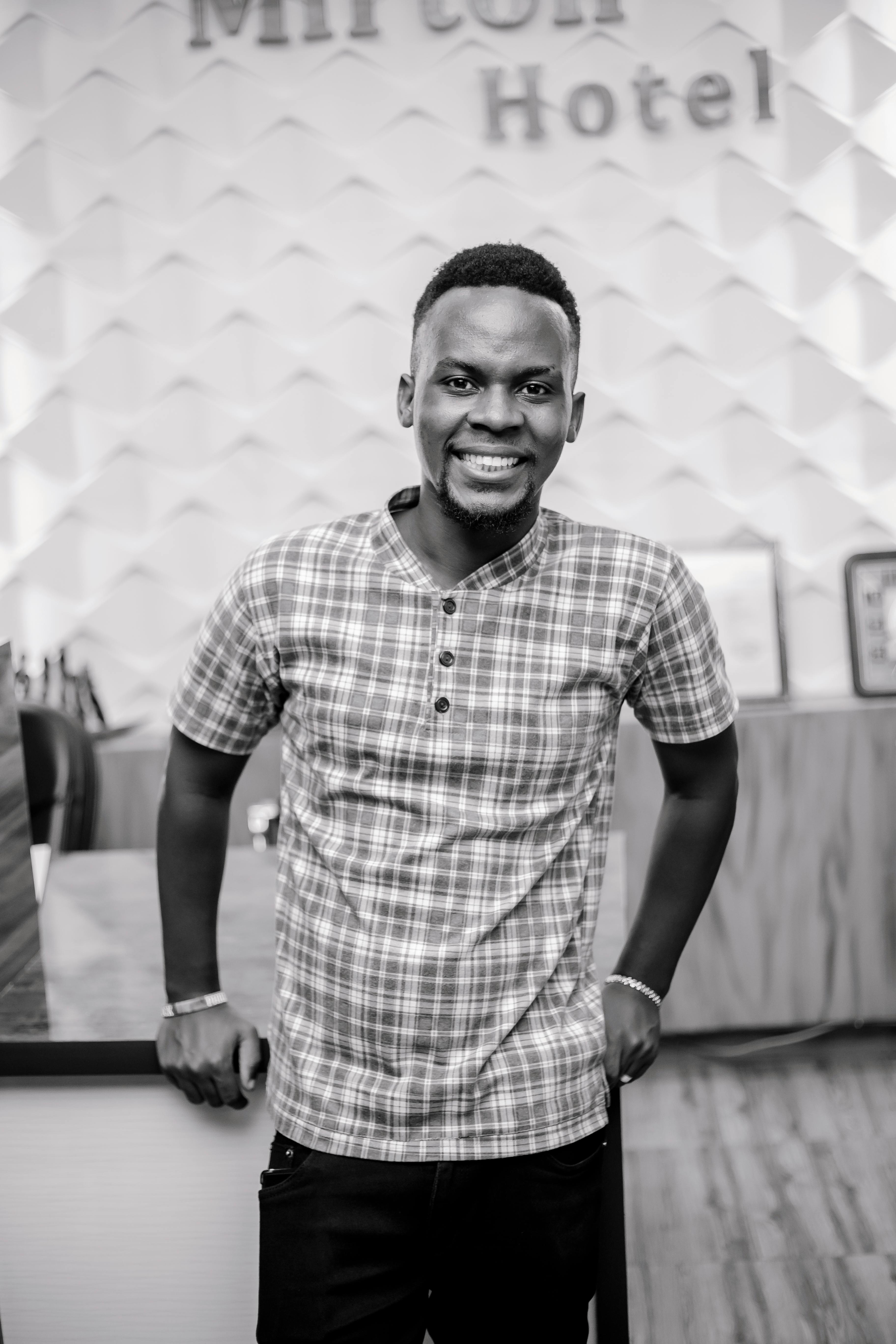 A joyful man posing in the stylish lobby of a hotel.