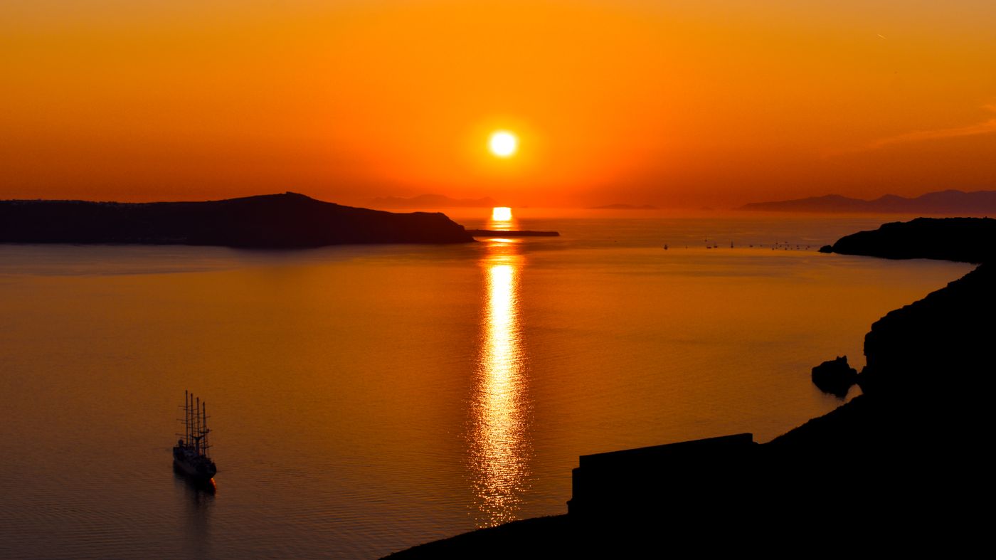 A ferry pulling into Santorini at dusk