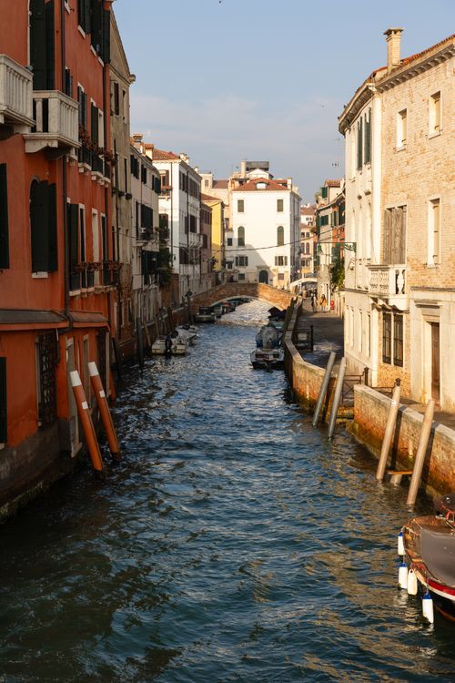 Free Explore the tranquil beauty of a Venice canal lined with historic buildings under the afternoon sun. Stock Photo