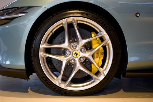 Free Detailed image showcasing a Ferrari's alloy wheel with yellow brake calipers highlighting design and engineering. Stock Photo