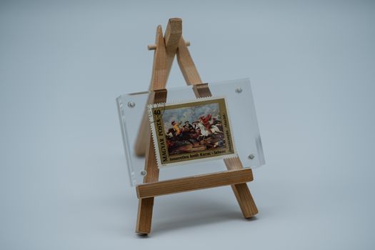 A classic Hungarian stamp presented on a mini wooden easel, offering a unique artistic touch.