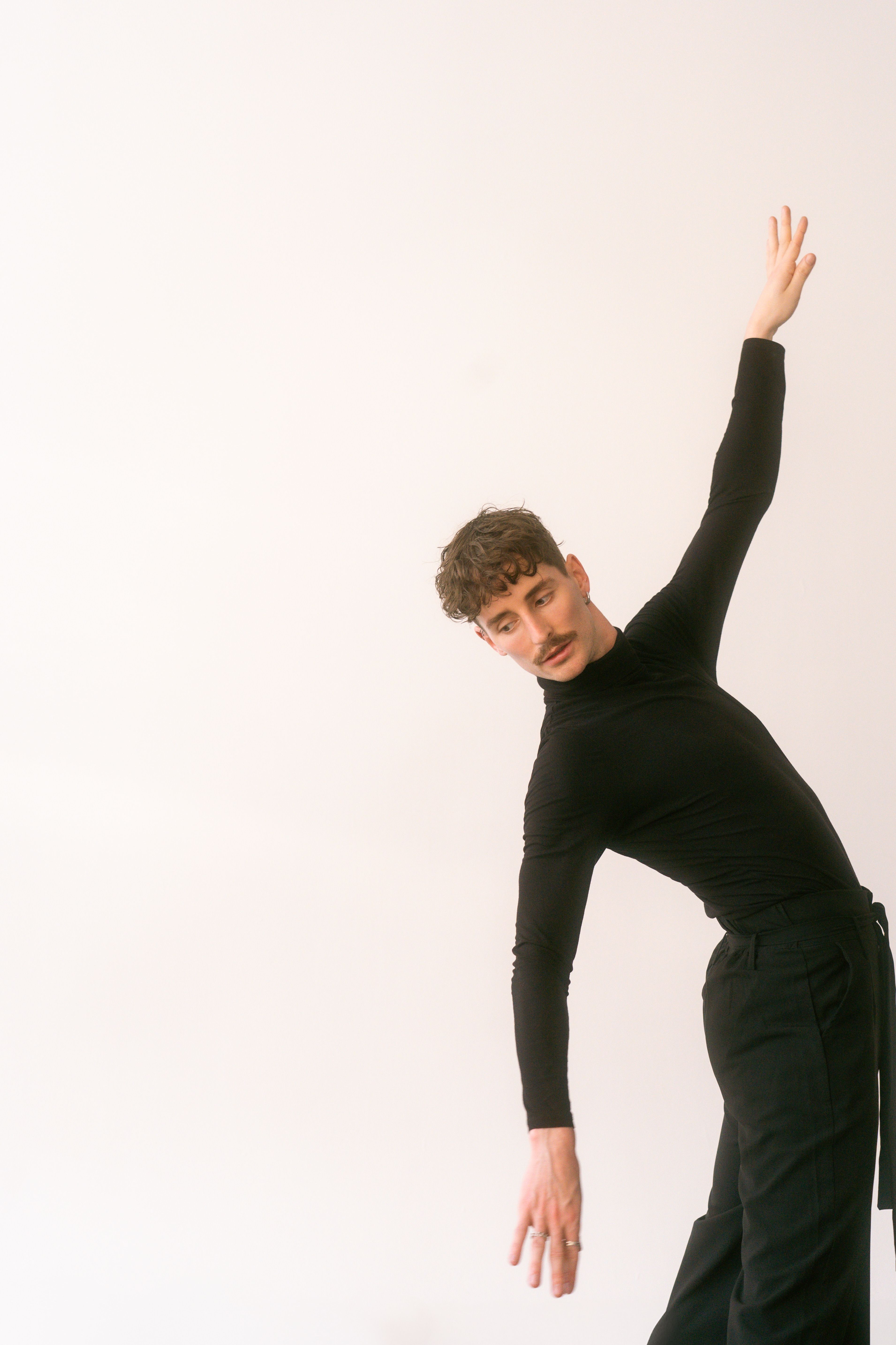 Portrait of a stylish dancer in a minimalist setting, showcasing grace and modern fashion.