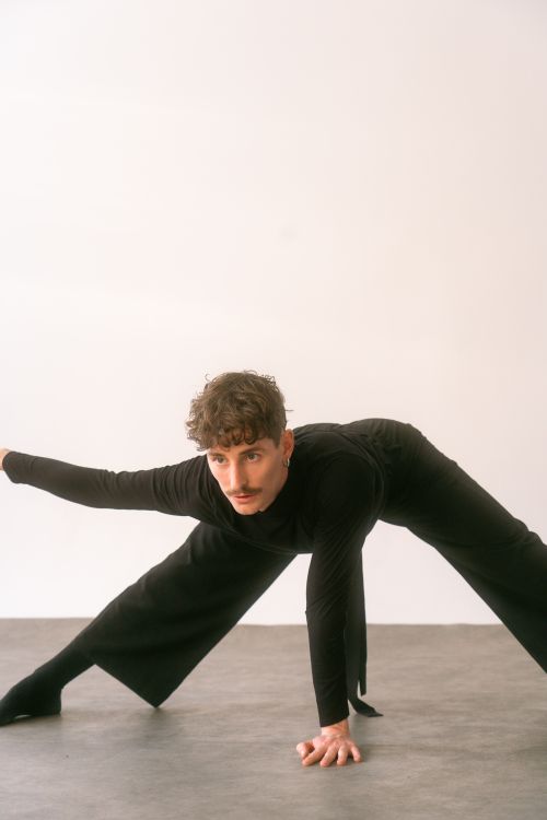 Free A dancer in a striking pose wearing black, captured in an indoor studio. Stock Photo