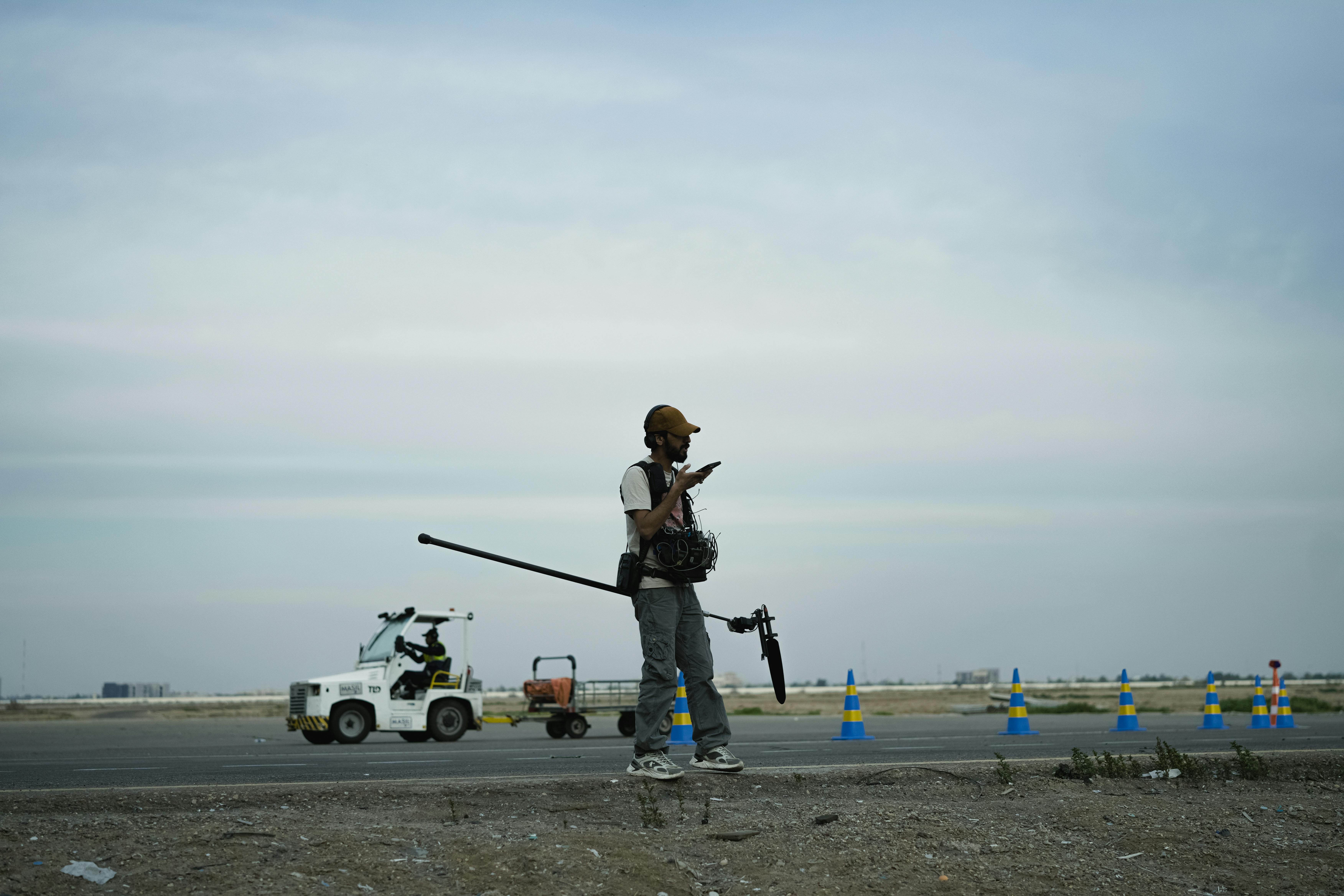A cameraman filming outdoor scene on road