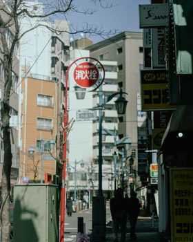 A bustling urban street with a prominent red fire hydrant sign, displaying vibrant city life.