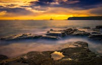 壮丽的沿海日落景色，岩石悬崖与绚烂天空，非常适合自然爱好者