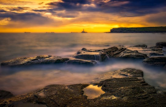 壮丽的沿海日落景色，岩石悬崖与绚烂天空，非常适合自然爱好者