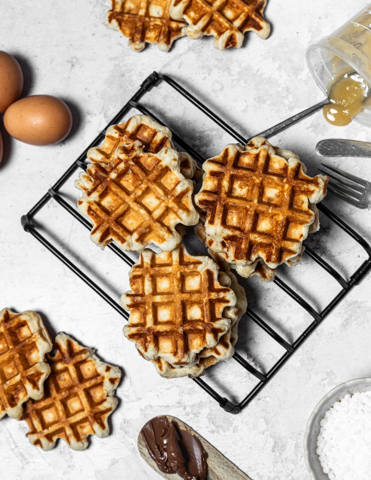 Homemade waffles resting on a cooling rack before storage