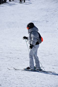 A skier dressed in winter gear enjoying the snowy slopes of a ski resort.