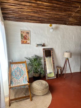 Inviting rustic room with wooden decor and plants in Kanthalloor, India.