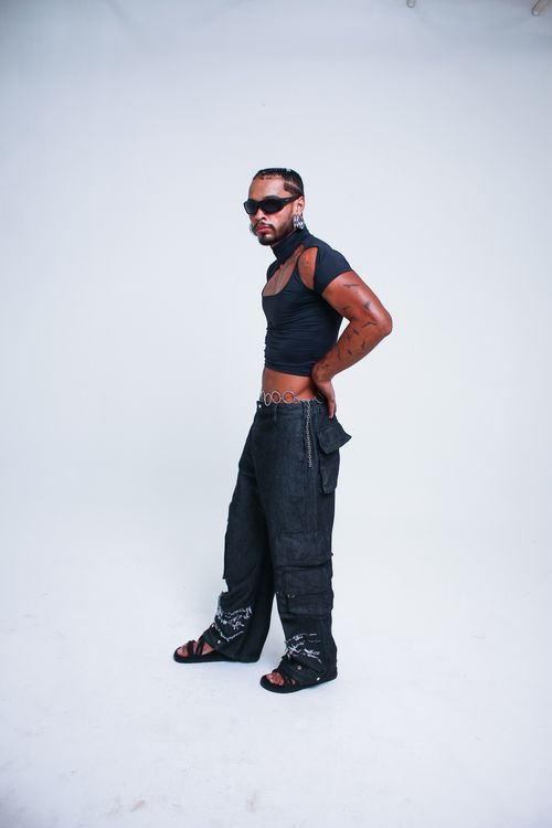 Free Stylish model in avant-garde clothing and sunglasses posing with attitude in studio. Stock Photo